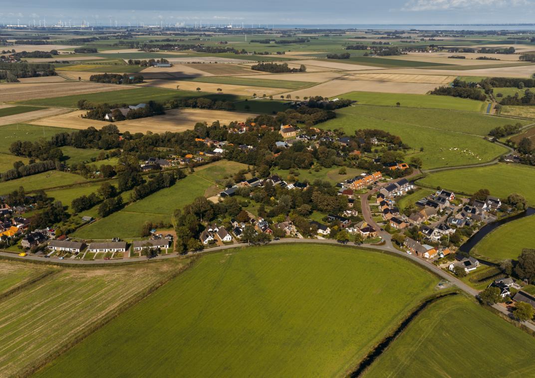 Wirdum in vogelvlucht op een dronefoto. Een dorp met smalle wegen. De dorpenaanpak betekent minder bouwverkeer in het dorp en daardoor minder bouwoverlast.