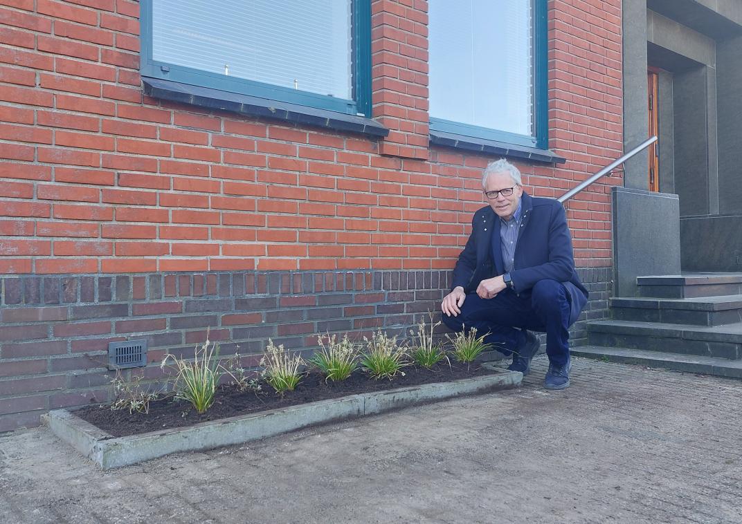 Wethouder Pier Prins met net aangelegd geveltuintje