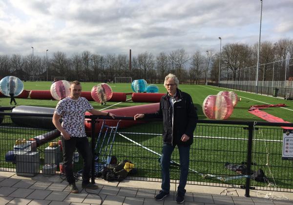 Martijn Oostenburg (jongerenwerker) en Pier Prins (wethouder gemeente Eemsdelta) bij sportpark Appingedam, op de achtergrond attributen van bubbelvoetbal