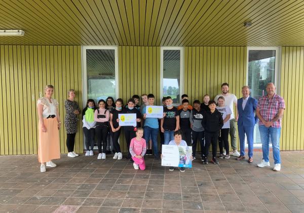 Groepsfoto van de leerlingen en docenten van Kindcentrum Noord in Delfzijl en wethouder Meindert Joostens