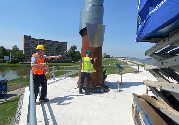 Wethouder Jan Menninga begeleidt de herplaatsing van het Ede Staal monument