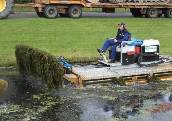 Maaiboot die waterplanten maait