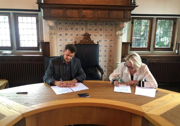 Annalies Usmany zet handtekening onder overeenkomst voor aankoop Action