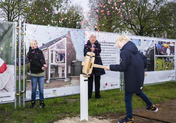 Een jongen slaat met een hamer op een paal onder een regen van confetti