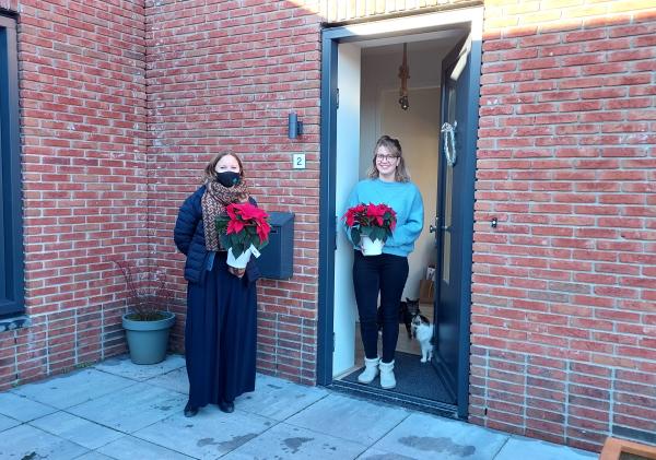 Een huurder van de woningbouwlocatie 'De Tip' ontvangt in haar deuropening een kerstster.