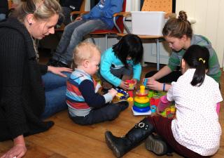 Samen Oplopen vrijwilliger speelt met eigen kind en kinderen gesteund gezin