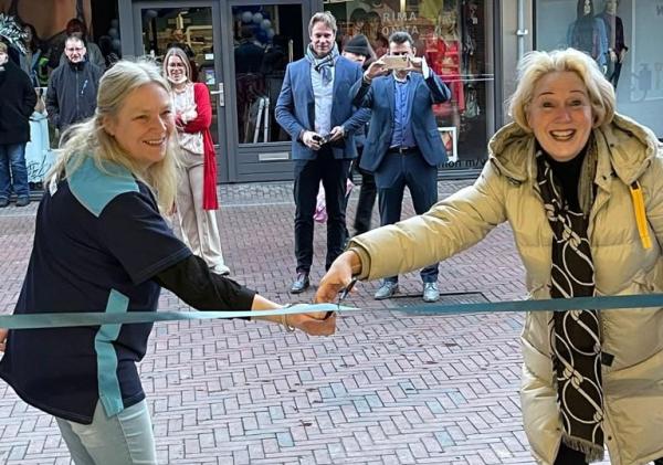 Wethouder Usmany knipt lint door voor de opening van de Actionwinkel in Delfzijl.