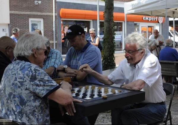 Wethouder Jan Menninga speelt een potje dammen