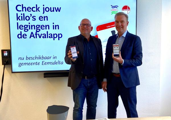 Wethouder Meindert Joostens (rechts) en Jelmer Helmhout (Omrin) bij de feestelijke lancering van de afvalapp in het Stadskantoor in Appingedam.