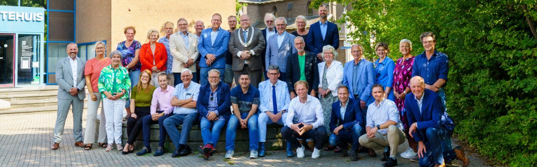 Groepsfoto van de gemeenteraad voor het gemeentehuis van Delfzijl