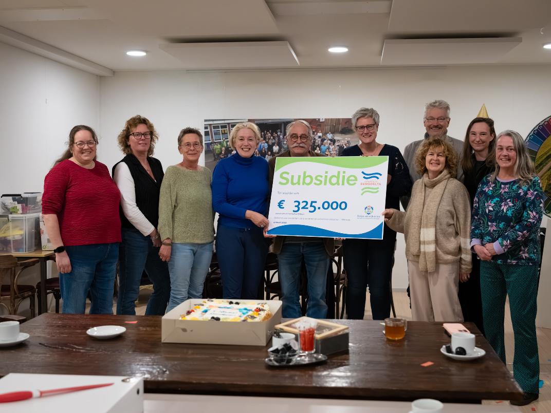 Personen staan op een rij met een cheque in de hand van 325.000 euro voor het realiseren van een dorps- of wijkvisie