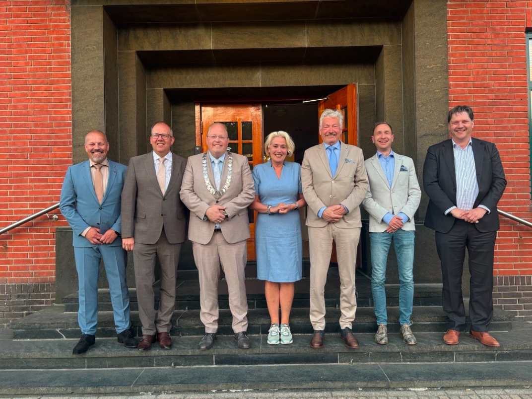 Het nieuwe college, de 6 nieuwe wethouders die op een rijtje staan voor het gemeentehuis , met in het midden de burgemeester Ben Visser
