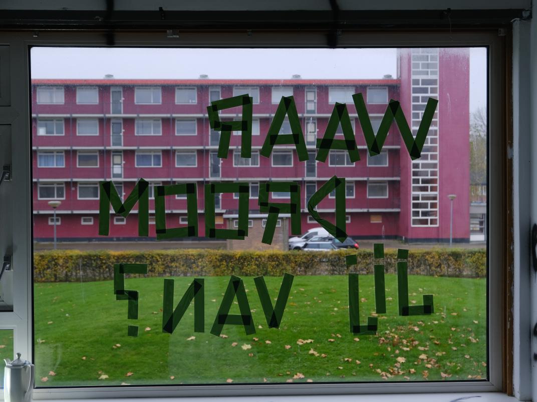 Woorden in spiegelbeeld die op een raam zijn geplakt met tape