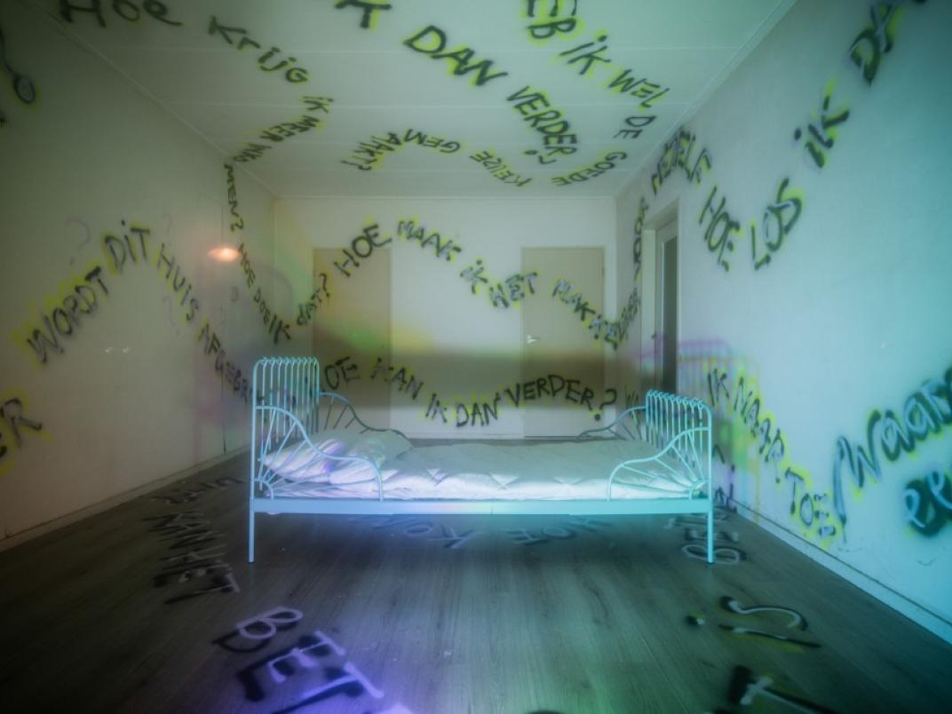 Bed in kamer met graffiti op de muren