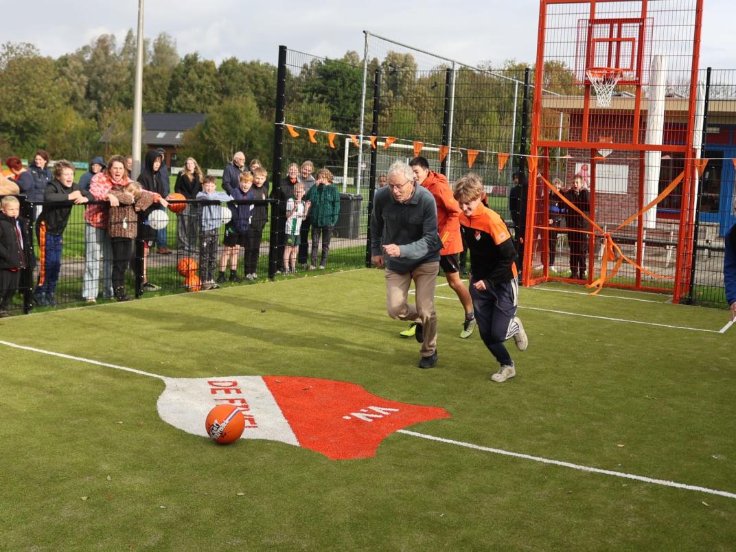 Pier Prins die op het punt staat tegen een voetbal aan te schoppen bij de opening van de pannakooi. 